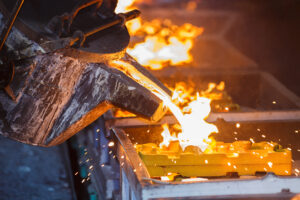 Molten metal is being poured into ceramic molds in a production line
